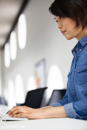 Asian businesswoman typing on a keyboard