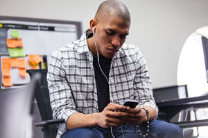 Student on smartphone with headphones