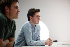 Two businessmen listening in a meeting