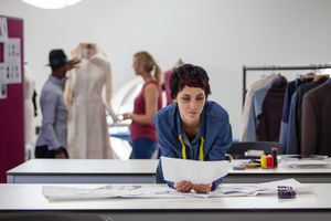 Fashion designer working on collection in busy studio