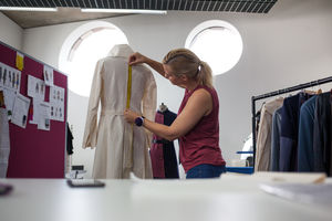 Fashion designer using a measuring tape