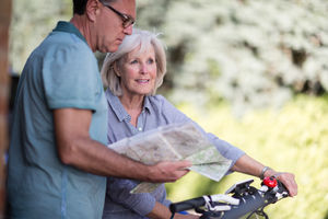 Senior couple looking at map on cycling vacation