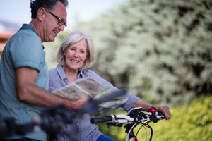 Senior couple looking at map on cycling vacation