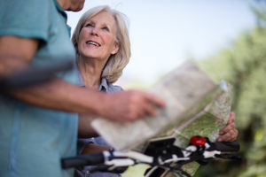 Senior couple looking at map on cycling vacation