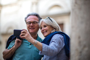 Senior couple on vacation taking a photo at a tourist site