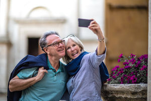 Senior couple on vacation taking a photo at a tourist site