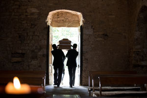 Pallbearers lifting a coffin