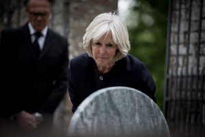 Senior woman reading a gravestone