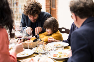 Father helping daughter cut her food