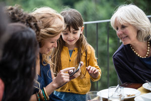 Generations of family all looking at smartphone together