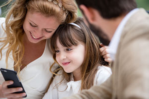 Bridge and Groom with Daughter looking at smartphone