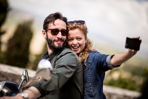 Young couple on motorbike taking a selfie