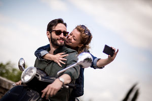 Young couple on motorbike taking a selfie