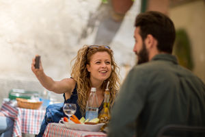 Young couple eating alfresco taking a selfie