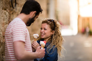 Young female eating gelato with boyfriend
