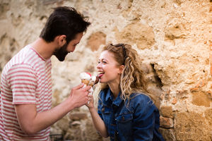 Young female eating gelato with boyfriend
