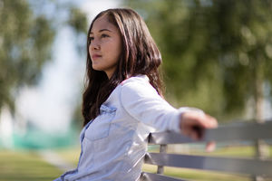 Woman sitting on bench in with takeout coffee