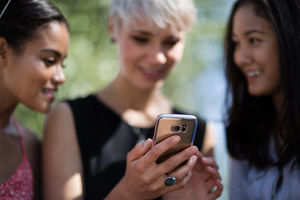 Close-up of  friends looking at smartphone