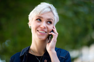 Young adult walking down street and checking smartphone