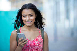Portrait of young adult commuting and using smartphone