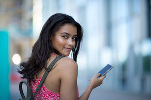 Portrait of young adult commuting and using smartphone