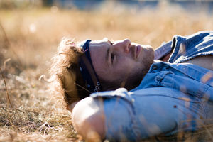 Young adult lying on grass in summer