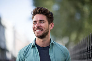 Young adult walking down street smiling