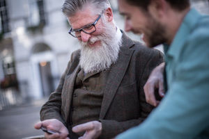 Senior and friend looking at smartphone