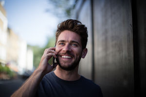 Young adult walking down street on phone