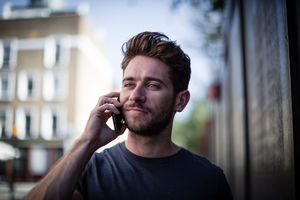 Young adult walking down street on phone