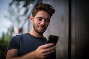 Young adult walking down street on phone