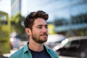 Young adult walking down busy road