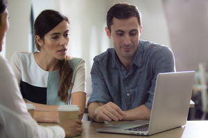 Colleagues in café looking at laptop