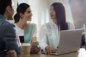 Colleagues in café looking at laptop
