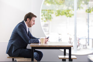 Businessman checking using smartphone in a café