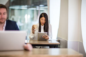 Businesswoman in a café reading a digital tablet