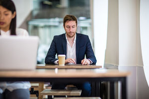 Businessman in a café reading a digital tablet