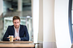 Businessman in a café reading a digital tablet