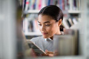 Student reading a book in library