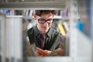 Student reading a book in library