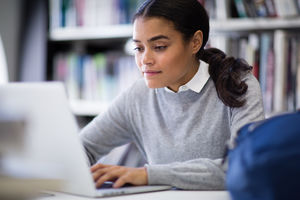 Student working on laptop in library