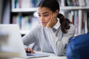 Student working on laptop in library
