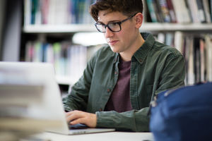 Student working on laptop in library