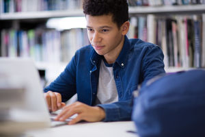 Student working on laptop in library