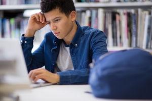 Student working on laptop in library