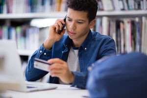 Student on phone with credit card