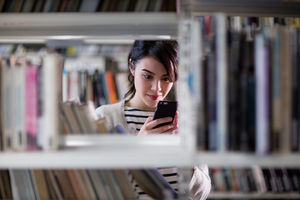 Student using smartphone in library