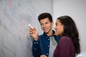 Students at a whiteboard with pen