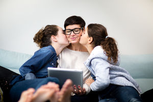 Daughters kissing Mum on  both cheeks