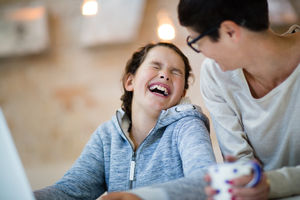 Daughter laughing with Mum at home